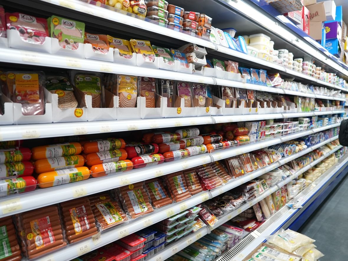 Inside Mega Food Centre — the chilled deli aisle of European cold cuts, cheese and dairy running the length of the shop